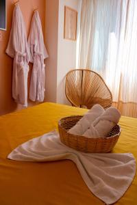 a basket of towels sitting on top of a bed at Axé home - Apartamento conceito em Salvador in Salvador