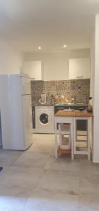 uma cozinha com um frigorífico e uma mesa em Vue de rêve em Calcatoggio