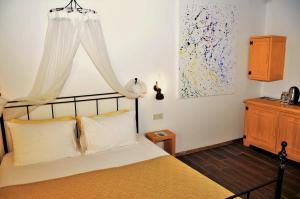 a bedroom with a bed with white pillows and a window at Assos Longevity Hotel in Sokakagzi