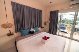 a bedroom with a large bed with a red bow on it at Arena Seaview in Ban Tai