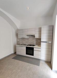 - une cuisine avec des placards blancs et une cuisinière dans l'établissement Il Cardinale, à Reggio de Calabre