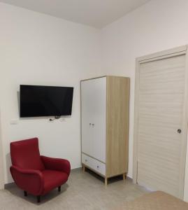 - un salon avec une chaise rouge et une armoire dans l'établissement Il Cardinale, à Reggio de Calabre