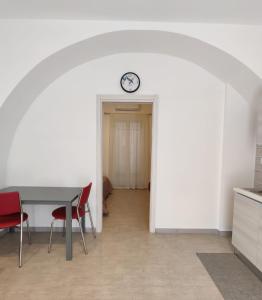 une salle à manger avec une table, des chaises et une horloge dans l'établissement Il Cardinale, à Reggio de Calabre