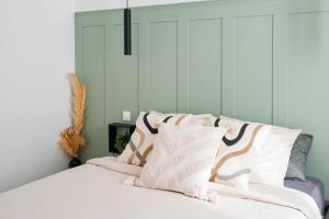 a bedroom with a bed with white sheets and pillows at La Capsule - Appartement Design et Cosy in Cambrai