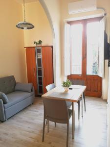 een woonkamer met een tafel en een bank bij Dietro Piazza Duomo in Acireale