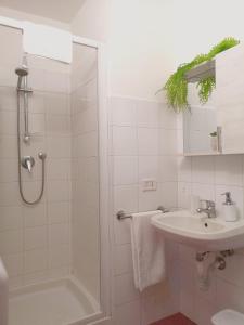 een witte badkamer met een douche en een wastafel bij Dietro Piazza Duomo in Acireale