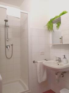 une salle de bain blanche avec une douche et un lavabo dans l'établissement Dietro Piazza Duomo, à Acireale