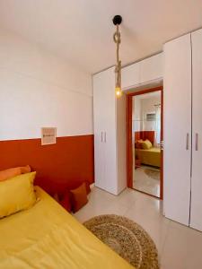 1 dormitorio con cama amarilla y sala de estar en Axé home - Apartamento conceito em Salvador, en Salvador