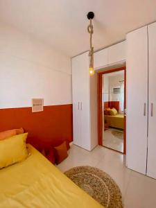 um quarto com uma cama amarela e uma sala de estar em Axé home - Apartamento conceito em Salvador em Salvador
