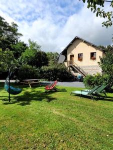 a yard with a house and some chairs in the grass at Le Charme Normand in Norville