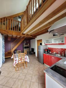 a kitchen with a table and a dining room at Le Charme Normand in Norville