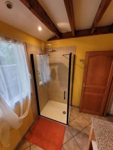 a shower with a glass door in a bathroom at Le Charme Normand in Norville