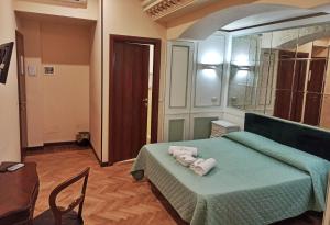 una camera da letto con un letto verde e asciugamani di Domina Popolo a Roma