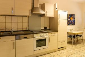 a kitchen with white cabinets and a sink and a stove at Ferienwohnung _Altstadt Northeim in Northeim