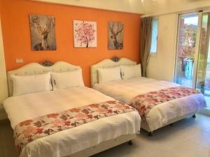 due letti in una stanza con pareti arancioni di Mi Hai B&B a Ji'an