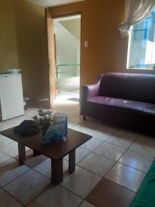 ein Wohnzimmer mit einem lila Sofa und einem Couchtisch in der Unterkunft Hospedaje Alfredo in Lima