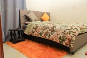 a bedroom with a bed with an orange rug at The Modern loft in Nairobi