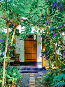 ścieżka prowadząca do drewnianych drzwi w ogrodzie w obiekcie Sunbird's Home w mieście Udawalawe