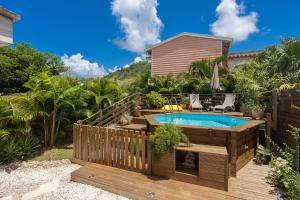 a backyard with a swimming pool and a wooden deck at Villa Mahana in Les Trois-Îlets