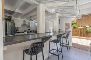 Villa Mahana في لي تروا زيليه: مطبخ وغرفة معيشة مع كونتر وكراسي
