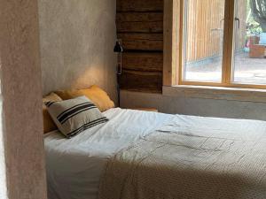 - un lit avec un oreiller et une fenêtre dans une chambre dans l'établissement Torpet1820, à Floda