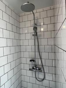 eine Dusche im Bad mit weißen Fliesen in der Unterkunft Torpet1820 in Floda