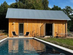 - un bâtiment en bois avec deux chaises et une piscine dans l'établissement Torpet1820, à Floda