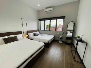 a bedroom with two beds and a mirror in it at Ipoh 19A Villa for 12pax 6 Carpark with BBQ by IWH in Ipoh