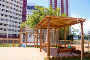 un pavillon en bois dans un parc avec de grands bâtiments dans l'établissement Axé home - Apartamento conceito em Salvador, à Salvador