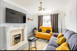 a living room with a couch and a fireplace at Entire Immaculate 3 Bedrooms House in Blackburn Weekend Away in Blackburn