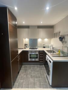 a kitchen with a stove and a dishwasher at The Retreat at Harlow in Potter Street