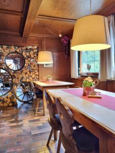 a dining room with two tables and a stone wall at Berghotel Almagmach in Immenstadt im Allgäu