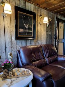 a leather couch in a room with a deer picture on the wall at Berghotel Almagmach in Immenstadt im Allgäu