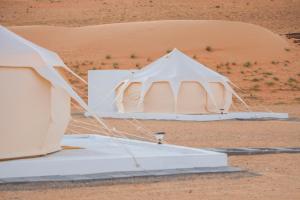 uma tenda branca no meio de um deserto em Safari Desert Camp em Shāhiq