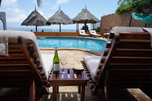 una bottiglia di vino su un tavolo accanto alla piscina di Zanzibar House Boutique Hotel a Matemwe