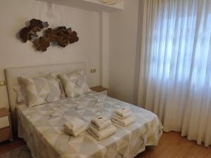 1 dormitorio con 1 cama con toallas en Los Caños de Rivero, con GARAJE y WIFI, VUT-4366-AS en Avilés