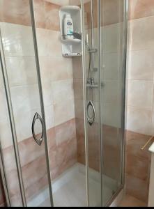 a shower with a glass door in a bathroom at Garcia Guest House in Verona