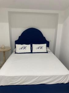 1 cama con cabecero azul y 2 almohadas blancas en Abagnale Home Sorrento en Sorrento