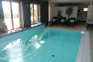 ein großes Schwimmbecken mit blauem Wasser in einem Gebäude in der Unterkunft Hanka Relax & Spa in Duszniki-Zdrój + 37 Fotos