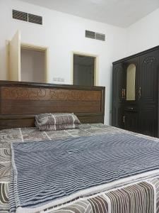 a bedroom with a large wooden bed with two pillows at Holiday Home 2 Bedrooms Apartment for Family Only in Sharjah