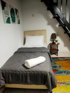ein Schlafzimmer mit einem Bett mit einem weißen Handtuch darauf in der Unterkunft Homestay 1 in Keluang
