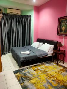 ein Schlafzimmer mit einem Bett und einer rosa Wand in der Unterkunft Homestay 1 in Keluang
