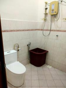 uma casa de banho com um WC e um chuveiro em Homestay 1 em Keluang