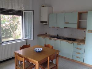 リド・ディ・イエゾロにあるApartment Istriaのキッチン(木製テーブル、椅子、テーブル、窓付)