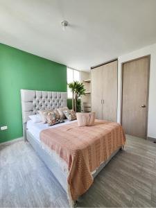 a bedroom with a large bed with a green wall at Peaceful & Modern Apartment in Cartagena de Indias