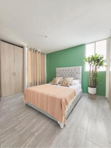 sypialnia z łóżkiem i zieloną ścianą w obiekcie Peaceful & Modern Apartment w mieście Cartagena de Indias