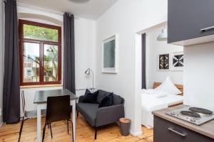 a studio apartment with a desk and a bed and a table at Künstlerzimmer im Kulturhaus Häselburg in Gera