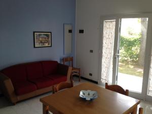 リド・ディ・イエゾロにあるApartment Istriaのリビングルーム(赤いソファ、テーブル付)