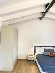 a bedroom with a blue bed and a white wall at CA'MASTEVA in Garda