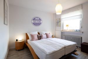 um quarto com uma cama grande e almofadas cor-de-rosa em Stilvolles City-Apartment mit Komfort & Gratis WLAN em Mönchengladbach